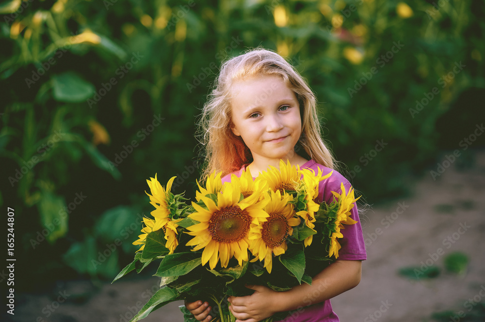 Portrait of a girl with a bouquet of sunflowers . The girl sitting on the road with flowers sunflower Portrait of a girl with a bouquet of sunflowers . The girl sitting on the road with flowers sunflower