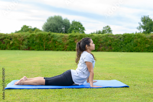 Teenage girl practising yoga outdoors