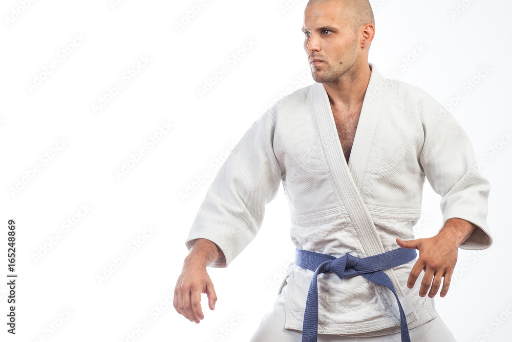 A young bald man in a white kimono and blue belt for a kimono, sambo,  jiujitsu stands in a fighting pose on an isolated white background Stock  Photo | Adobe Stock