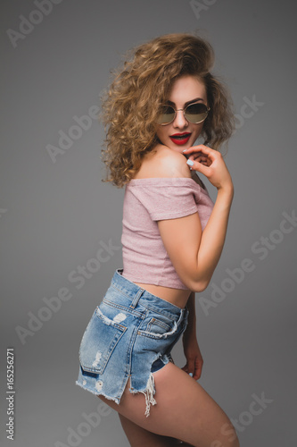 Stylish hipster fashion portrait of trendy casual young woman in sunglasses and hat  in studio © F8  \ Suport Ukraine