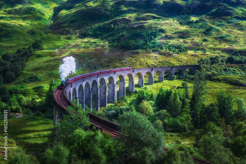 Glenfinnan Railway Viaduct in Scotland with a steam train photo