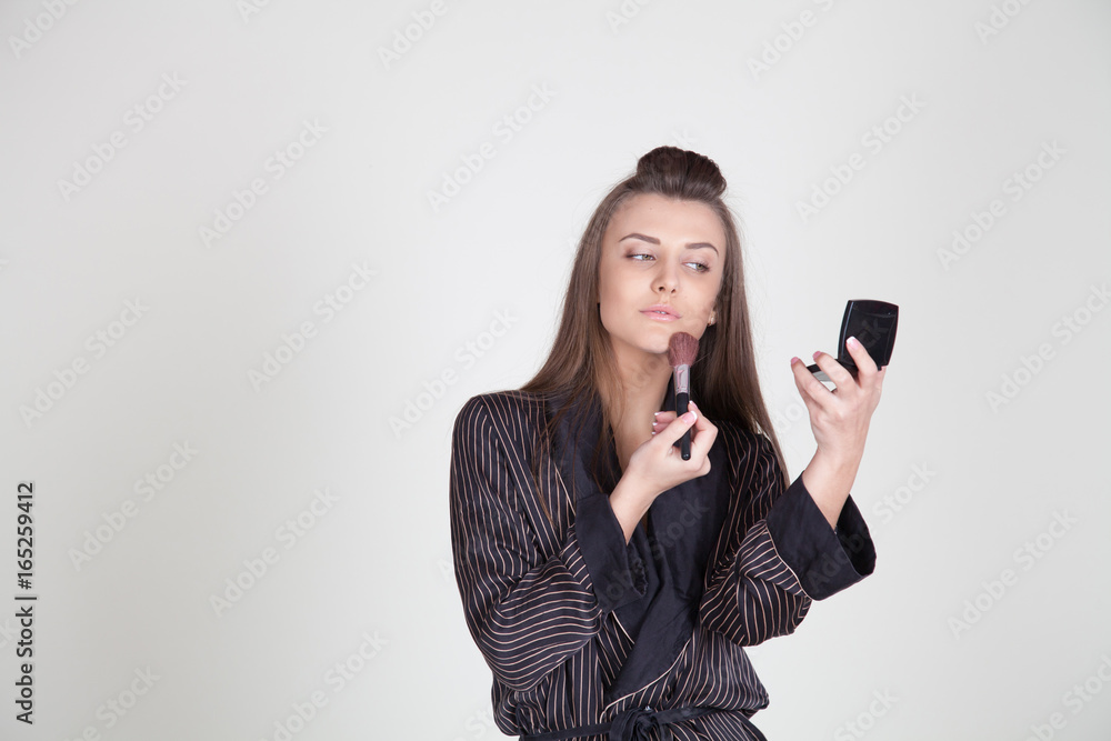 girl in coat makes brush makeup looks in the mirror girl in coat makes brush makeup looks in the mirror