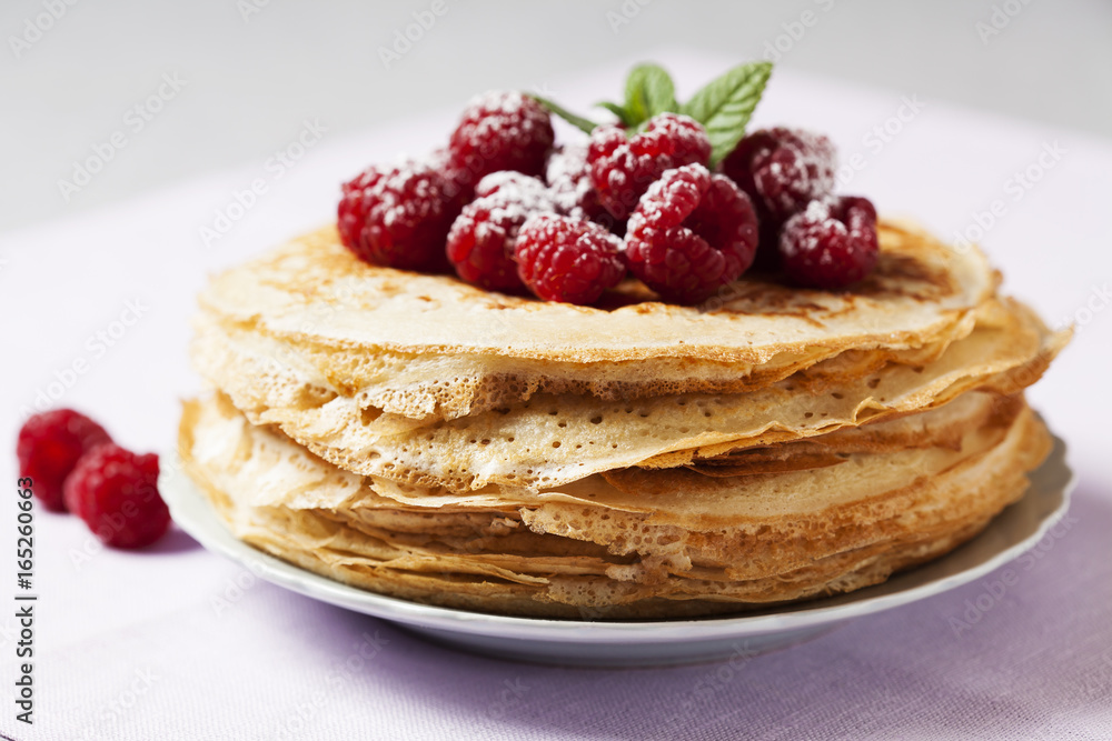 Stack of Russian-style pancakes with raspberries Stack of Russian-style pancakes with raspberries