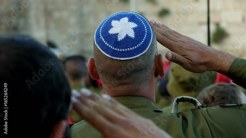 Israeli soldier military man saluting to the Western wall in Jerusalem. Western wall or Wailing wall or Kotel is the most sacred place for all jewish people.