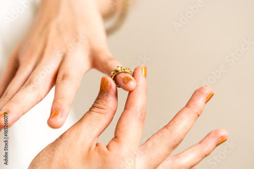 指輪をつける女性