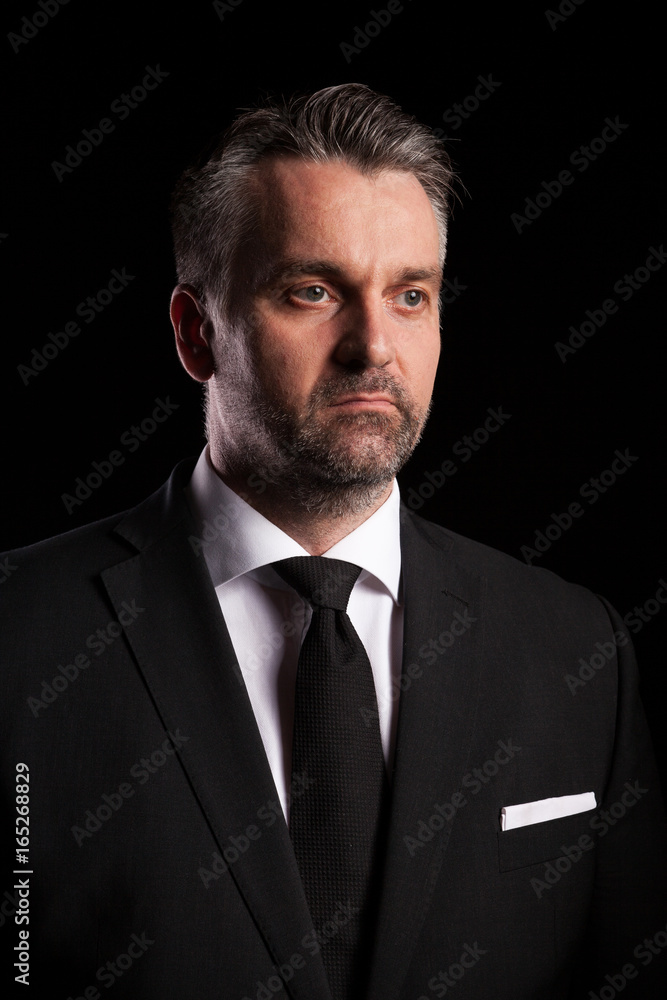 Dramatic portrait of businessman on black background in studio photo Dramatic portrait of businessman on black background in studio photo
