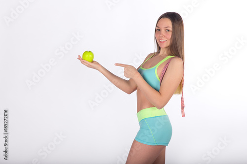 Fitness woman points finger at apple