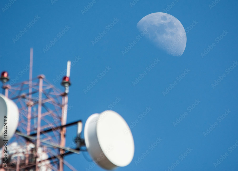 Radio antenna over blue sky and moon