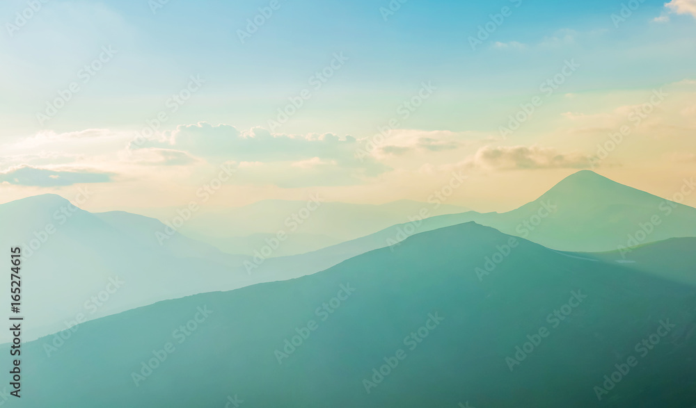 Fairytale panorama of mountain ranges in the twilight and clouds, pastel colors
