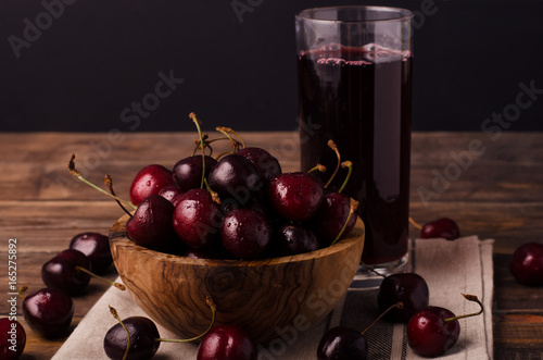 Fresh cherries on wooden table with cherry juice