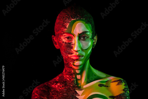 Woman with Extreme fashion make up in red and green studio light. Beauty and fashion. On stage make up 