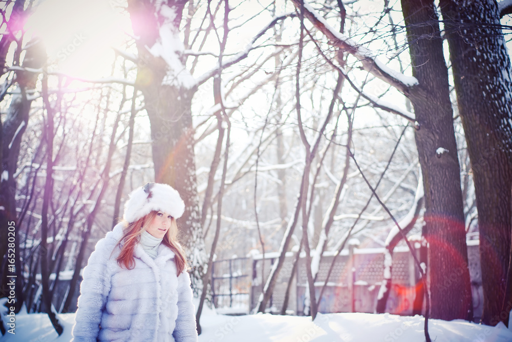 Beautiful girl in a winter snowy park