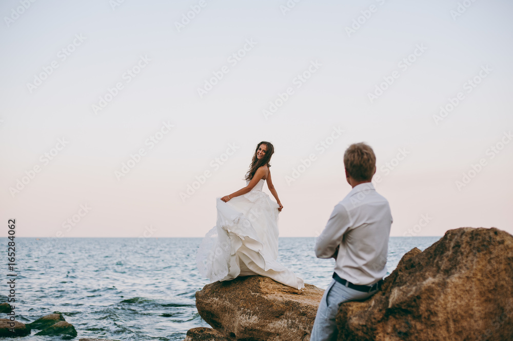 Fototapeta premium Beautiful wedding couple on a walk by the sea