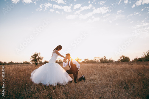 Wedding couple strolling in a valley with dry grass