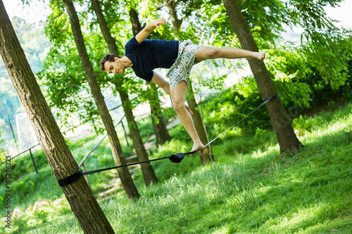 Fotografie young guy on slack line