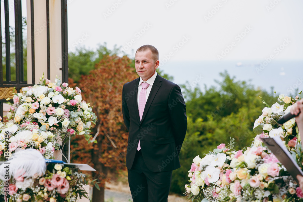 Bridegroom is waiting for her bride at the ceremony Bridegroom is waiting for her bride at the ceremony