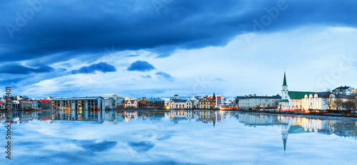 Beautiful panorama of the skyline cityscape of Reykjavik, reflected in lake Tjornin at the blue hour in winter