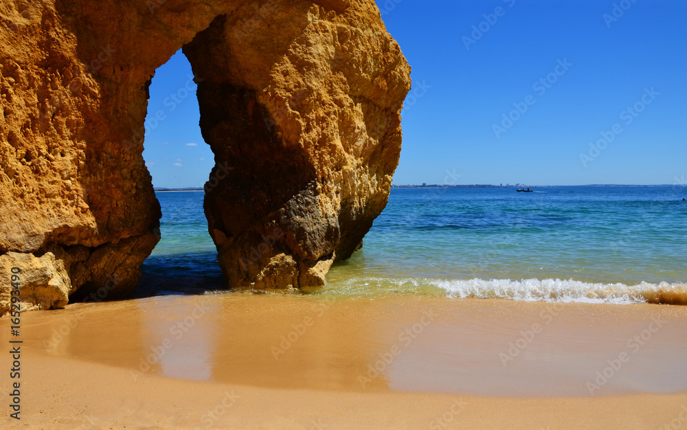Famous gap between rocks at Camilo Beach (Praia do Camilo) at Algarve, Portugal with turquoise sea in background