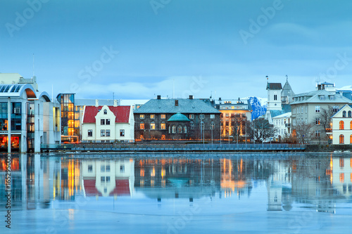 Beautiful reflection of the parliament house Althing of Reykjavik in lake Tjornin at the blue 