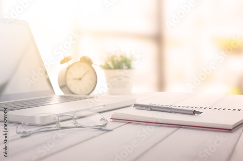 Businessman making notes at the office meeting with computer laptop and glasses.