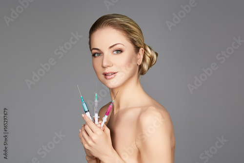 beautiful girl holding syringes