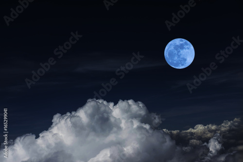 Blue full moon and cloud in the dark sky at night , color effect