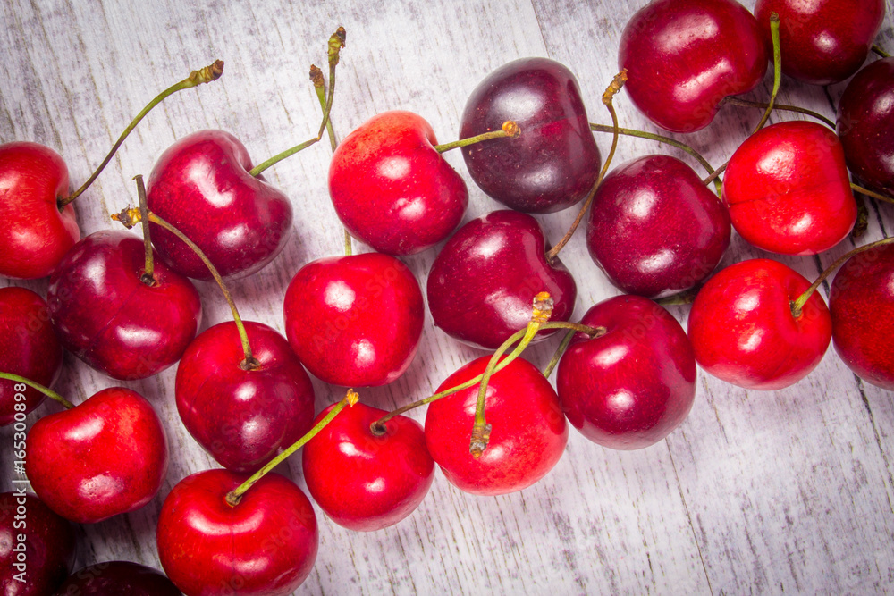 Fresh cherries on rustic wood background.