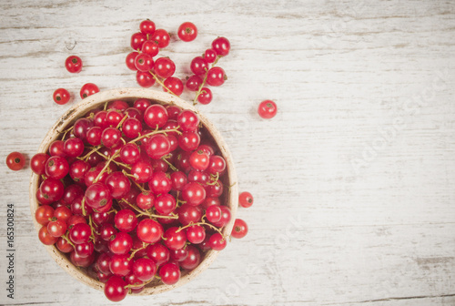 Fresh ripe red currants on rustic wood background.