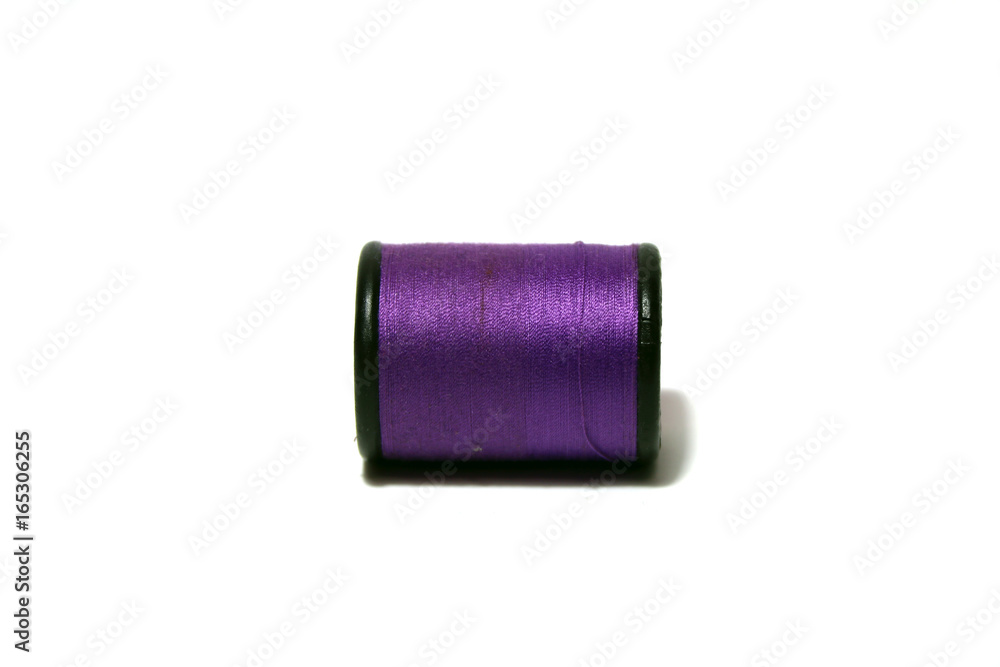 Purple thread in the black thread roll on white background. Prepare to use for sewing garment. Purple thread in the black thread roll on white background. Prepare to use for sewing garment.