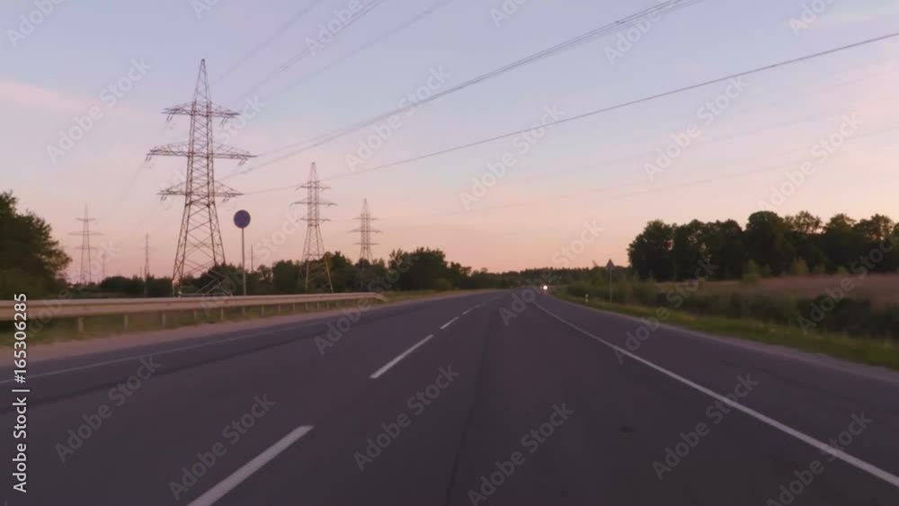 Travel around Europe by car. Shot at In evening sunset in a 2 way road crossing small cities. Driving a car on a country road POV .Point of view front windshield. Driving the car at sunrise. Travel around Europe by car. Shot at In evening sunset in a 2 way road crossing small cities. Driving a car on a country road POV .Point of view front windshield. Driving the car at sunrise.