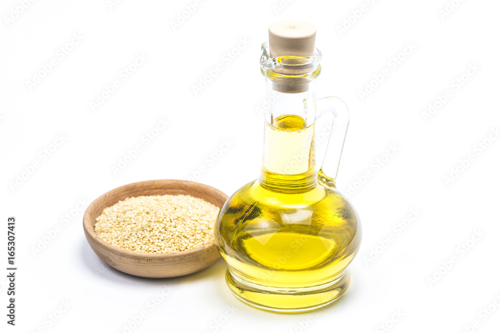 Sesame seeds and bottle with oil on a old wooden table?Sesame oil oil in a glass jug. Sesame seeds and bottle with oil on a old wooden table?Sesame oil oil in a glass jug.