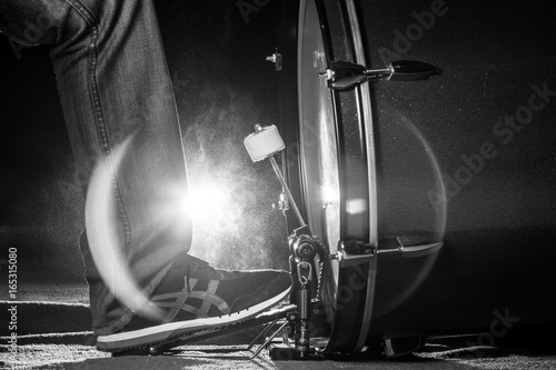 The drummer's foot wears sneaker is playing bass drum pedal