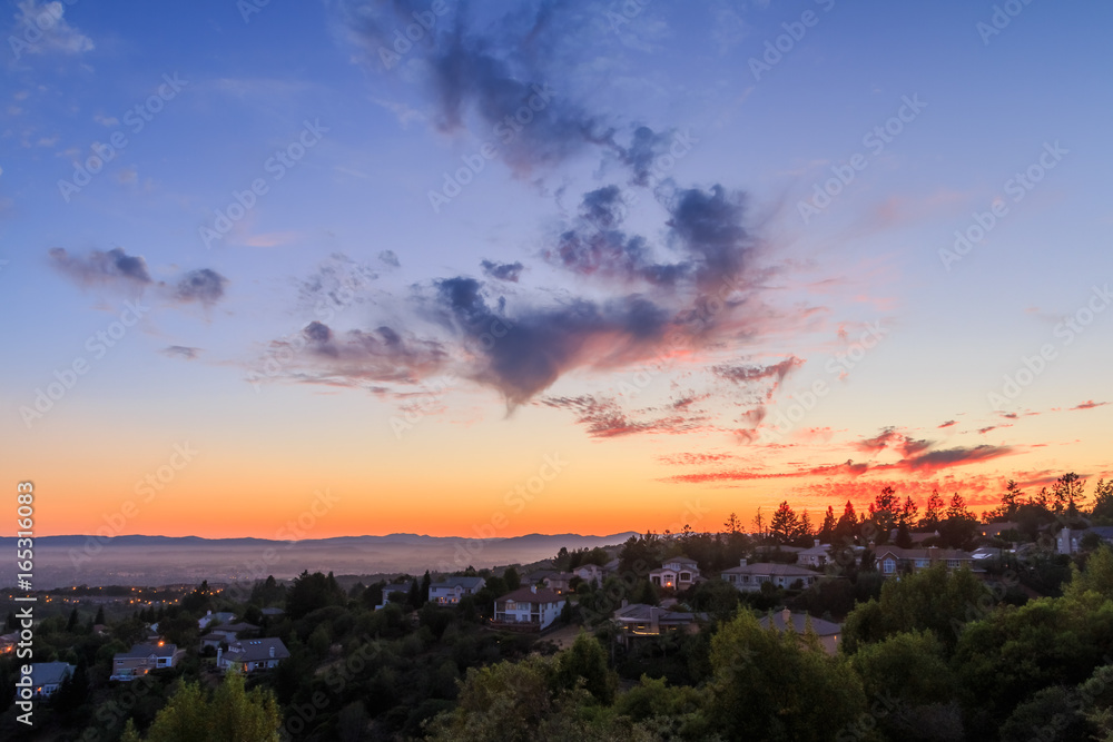Vibrant sunset over a broad valley and homes Vibrant sunset over a broad valley and homes
