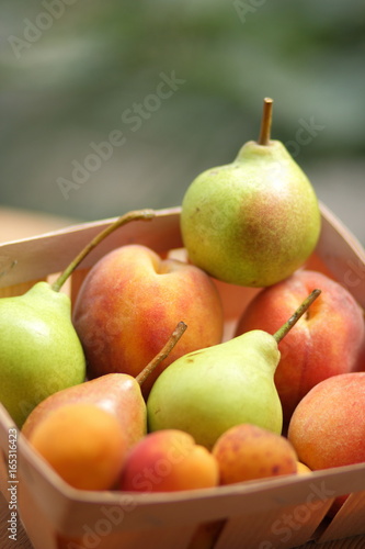 Pears and peaches in a wooden basket