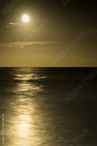 full moon rises over the Atlantic Ocean in South Carolina with a beautiful tranquil ocean