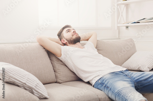 Handsome young man relaxing on the couch at home