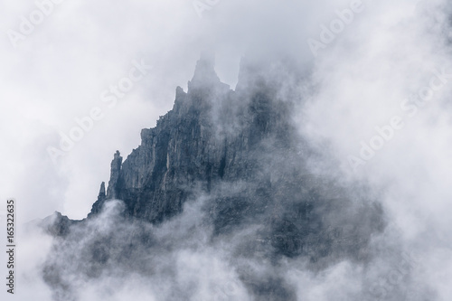 jagged mystical mountain ridge in the Swiss Alps in mist and fog
