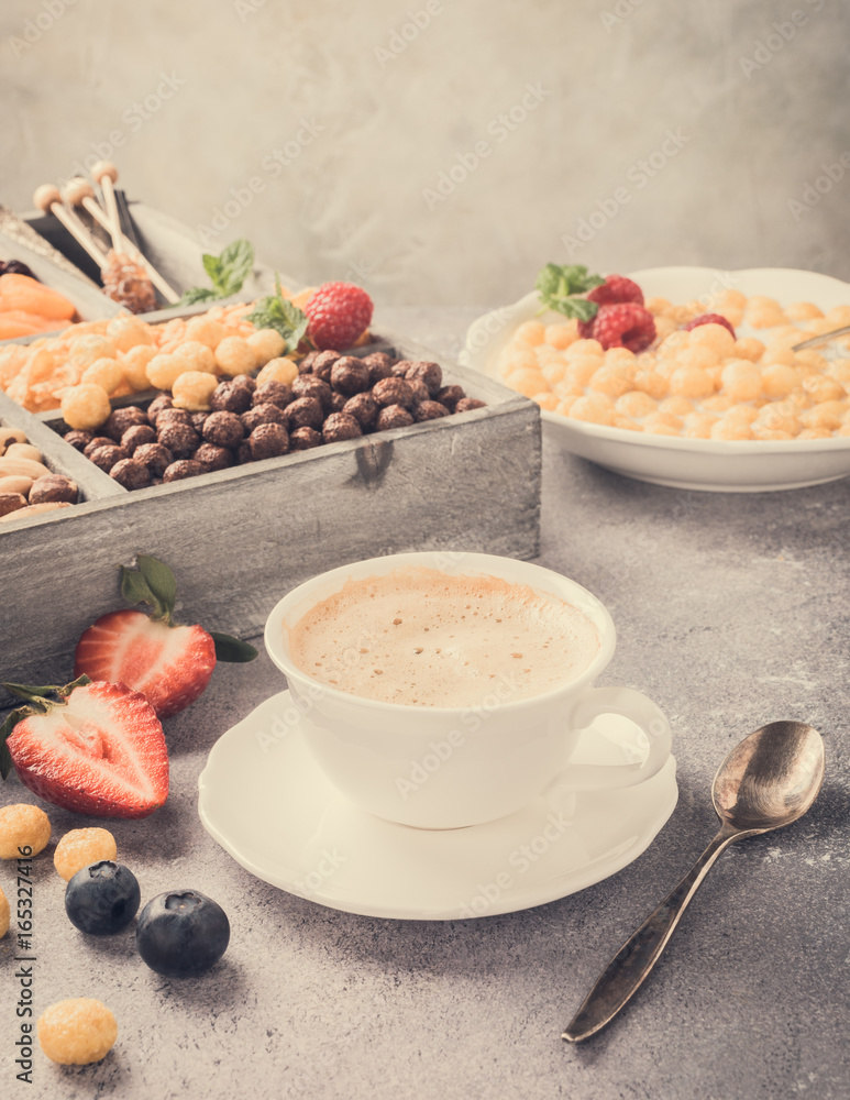 Healthy breakfast with coffee, variety of cold quick breakfast cereals and berries in old gray wooden box, selective focus. Retro style toned.