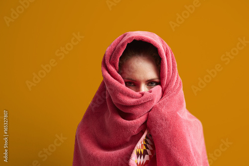 Young woman frapping in a towel on a yellow background. photo