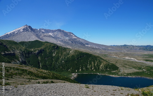 Mount St. Helens volcano and Spirit Lake 35 years after eruption. One side of the volcano collapsed and caused a landslide crashing into Spirit Lake. A new cone is forming in the old volcano.