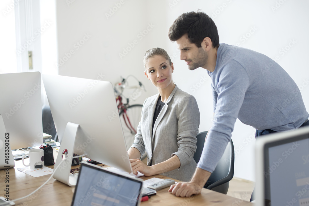 Teamwork in the designer studio. Shot of a beautiful young businesswoman and a handsome businessman working together on computer. Teamwork in the designer studio. Shot of a beautiful young businesswoman and a handsome businessman working together on computer.