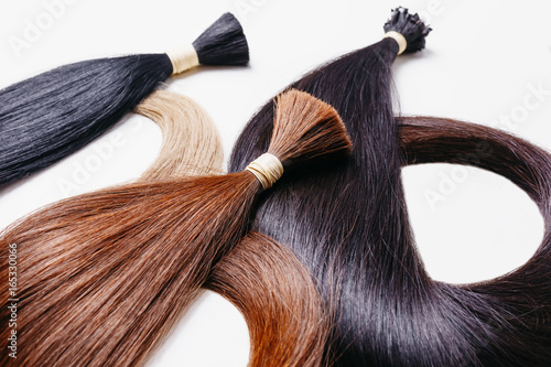 hair extensions of three colors on a white background. copyspace selective focus photo