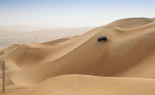 car driving in Rub al Khali Desert at the Empty Quarter, in Abu Dhabi, UAE