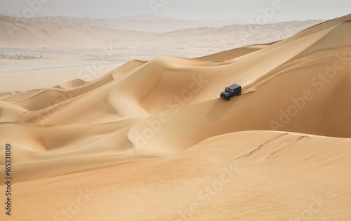Canvas Print car driving in Rub al Khali Desert at the Empty Quarter, in Abu Dhabi, UAE