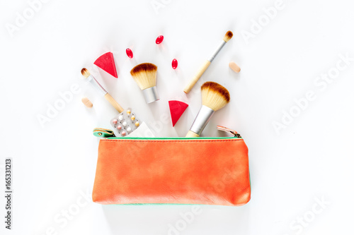 Beauty bag with cosmetics, contraceptives and pills on white table background top view copyspace photo