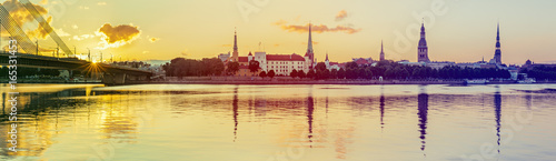 Panoramic view on old Riga city from left bank of the Daugava river. Riga is the capital of Latvia and famous Baltic city widely known among tourists due to its unique medieval and Gothic architecture