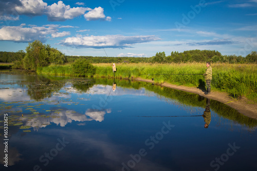 Fototapeta Naklejka Na Ścianę i Meble -  Fishing on the lake with lilies in rural location