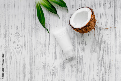Organic cosmetics with coconut. Coconut cream on wooden background top view copyspace