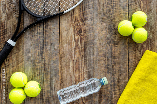 Sport background. Traning cocept. Tennis balls, racket, towel and water on wooden background top view copyspace © 9dreamstudio