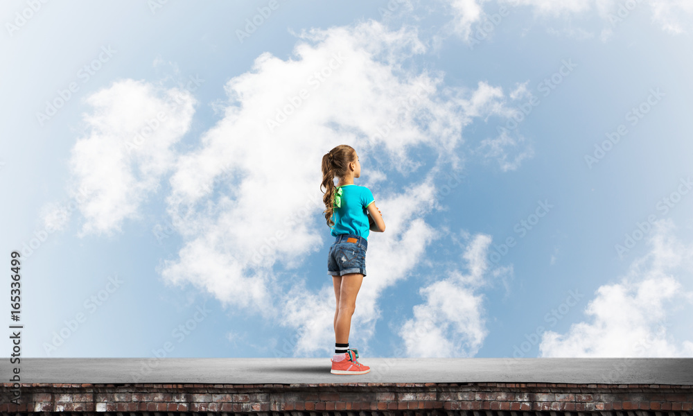 Concept of careless happy childhood with girl looking far away Concept of careless happy childhood with girl looking far away